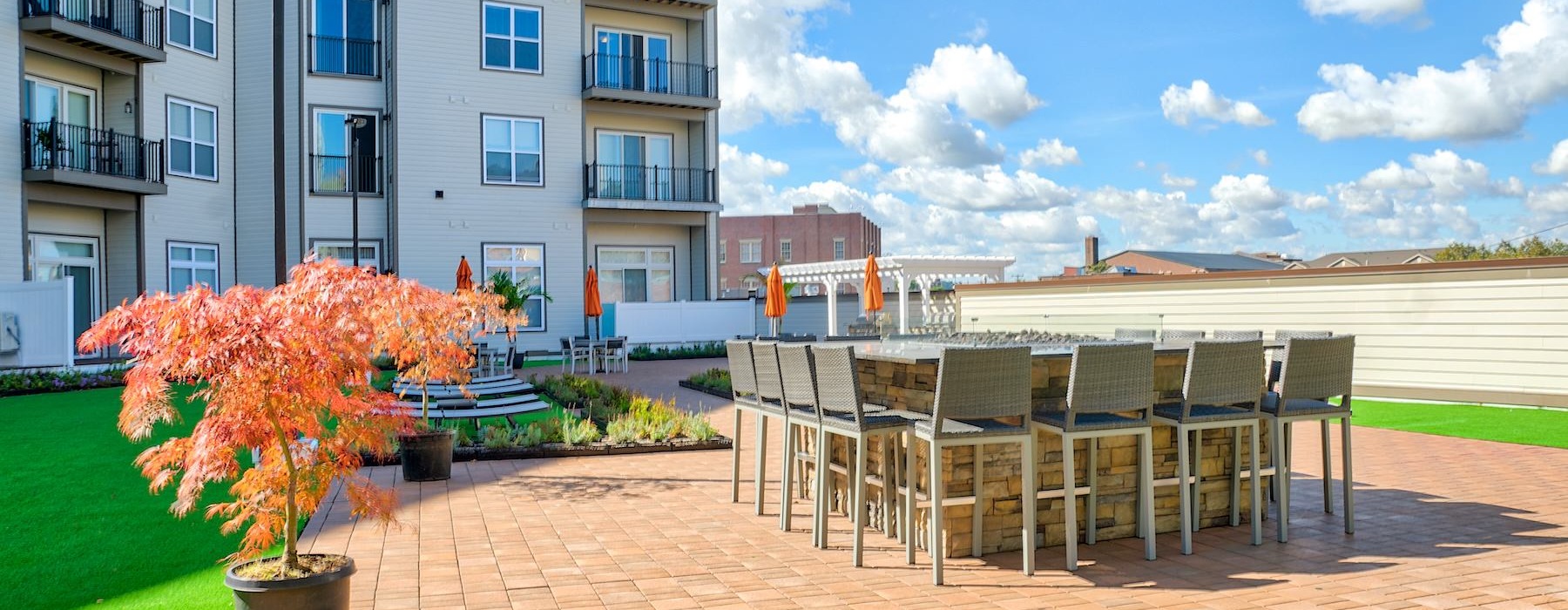 outdoor patio with large table seating and grass
